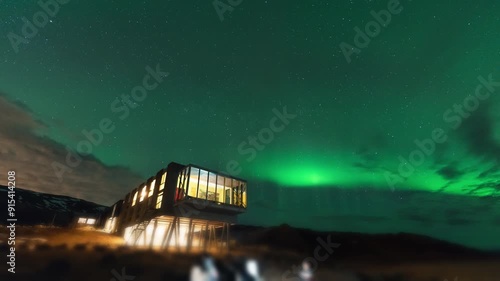 Aurora borealis, Northern lights glowing over luxury hotel on mount Hengill in winter at Iceland