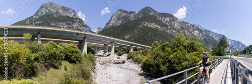 woman with e-bike on the alpe adria cycle route ( Pontebanna )  through the Val Canale in Italy