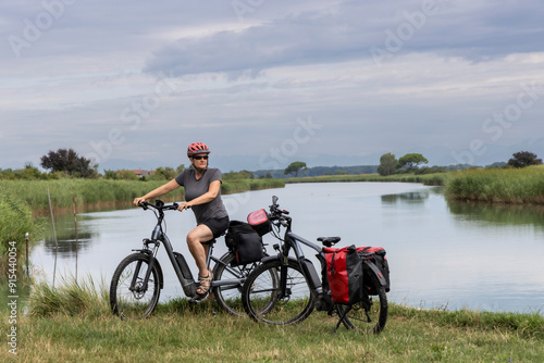 Obraz na płótnie Woman cycling through regional nature reserve of the mouth of the Isonzo,Friuli Venezia Giulia, Italy w salonie