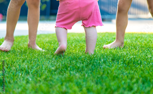 Children's legs run on green grass. children.