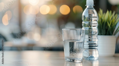 Clear Glass of Water Next to Plastic Bottle on Table With Blurred Background ...