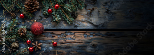 xmas holiday natural decoration: pine cones & red baubbles & christmas tree branch on wooden table background; widescreen backdrop; empty space; copy space photo