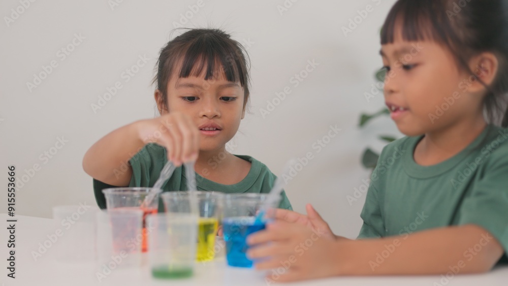 Two children are playing with a science experiment involving water Two children are playing with a science experiment involving water