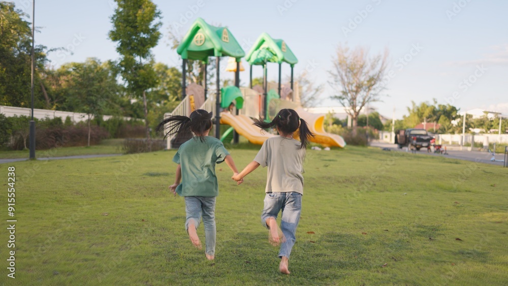 Obraz premium Two little girls running in a park