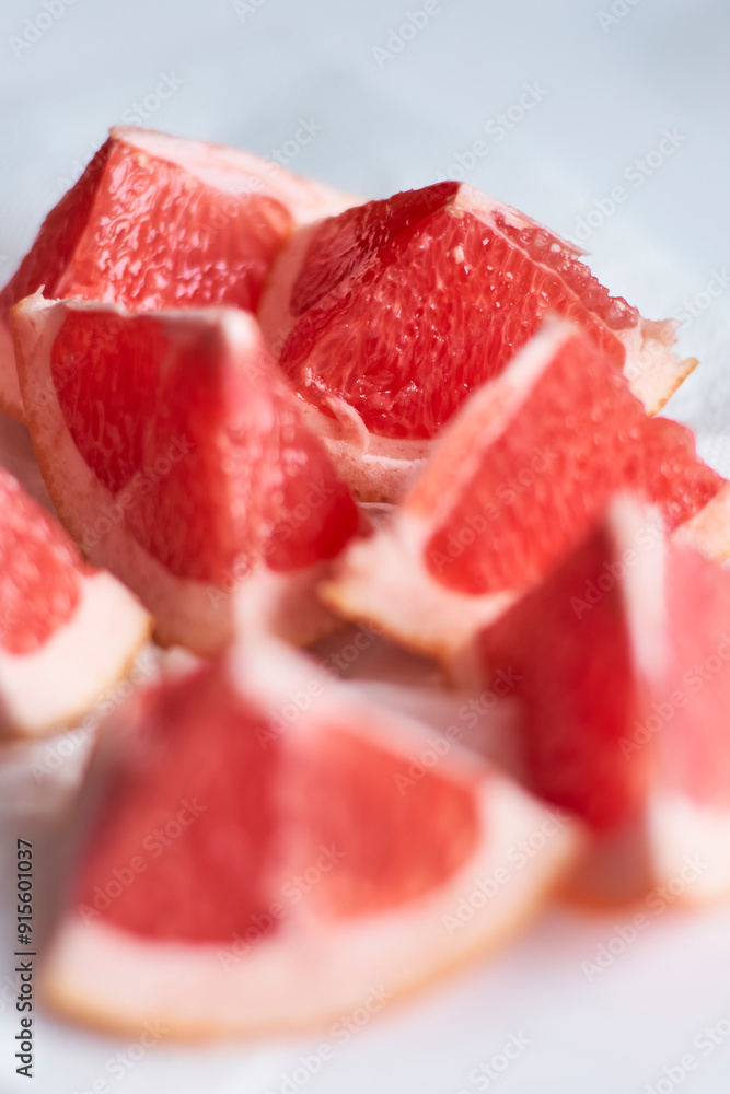 Freshly cut grapefruit segments arranged on a plate with natural light illuminating the textures