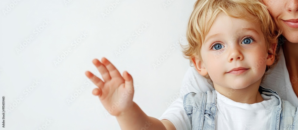 A clever little blond blue eyed child extends his hand forward while sitting with his lovely young mother against a white background Space for text. with copy space image A clever little blond blue eyed child extends his hand forward while sitting with his lovely young mother against a white background Space for text. with copy space image