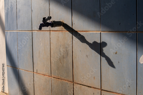 Принти на полотні A public water tap for ablution with its shadow on the wall