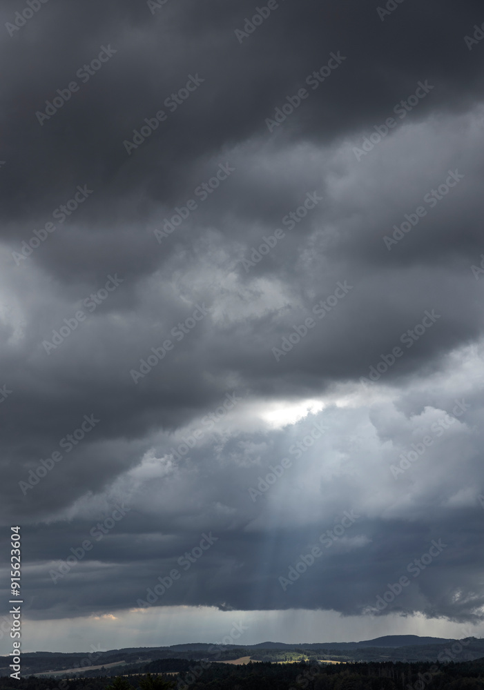 Dark rain and thunder clouds. Saxonia. Germany. Hills. Sunbeams. Dark rain and thunder clouds. Saxonia. Germany. Hills. Sunbeams.