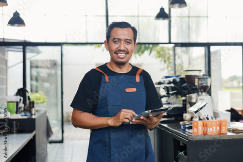 Restaurant, tablet and happy asian man or small business owner, e commerce and online cafe or coffee shop management photo