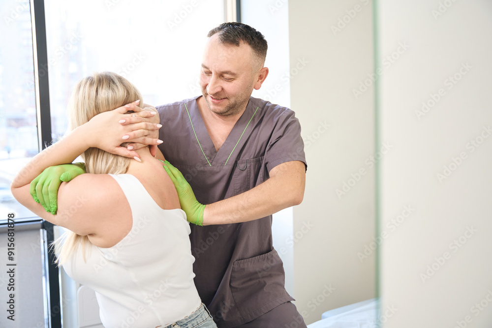 Fototapeta premium Osteopathic physician treating patient during manipulative therapy