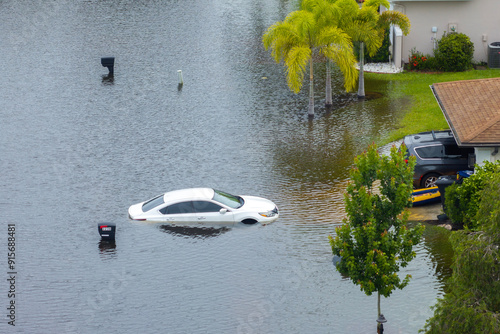 Flooded car and house from hurricane Debby rainfall water in Laurel Meadows community in Sarasota, Florida. Aftermath of natural disaster in USA south photo