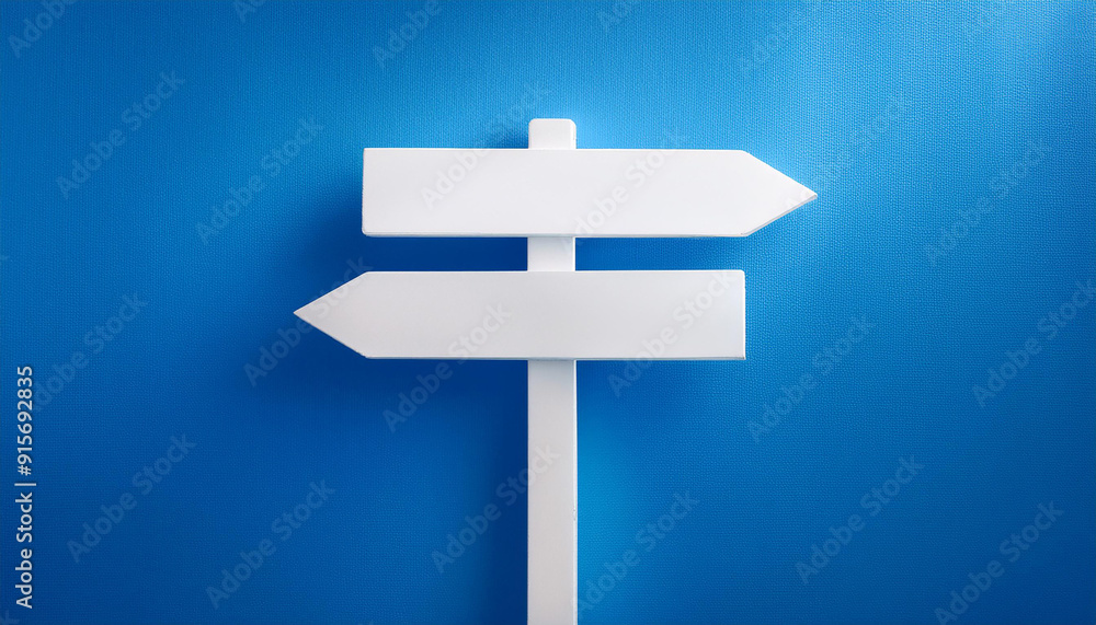 White direction sign on blue background. Pointing arrow. Close-up. White direction sign on blue background. Pointing arrow. Close-up.