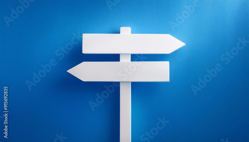 White direction sign on blue background. Pointing arrow. Close-up.