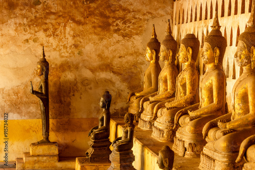 monk in the cloister wall with more than 2,000 ceramic and silver Buddha images in Wat Si Saket features in Vientiane , Laos photo