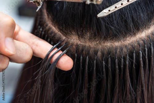 Valokuva Professional female hairdresser shows keratin hair extensions tips to long-haired woman in hair salon