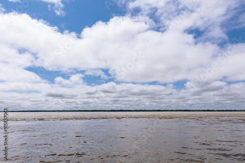 Confluence of two dark and light waters of the Amazon River with the Nanay River. In the Amazon jungle, near Iquitos, Peru. South America.