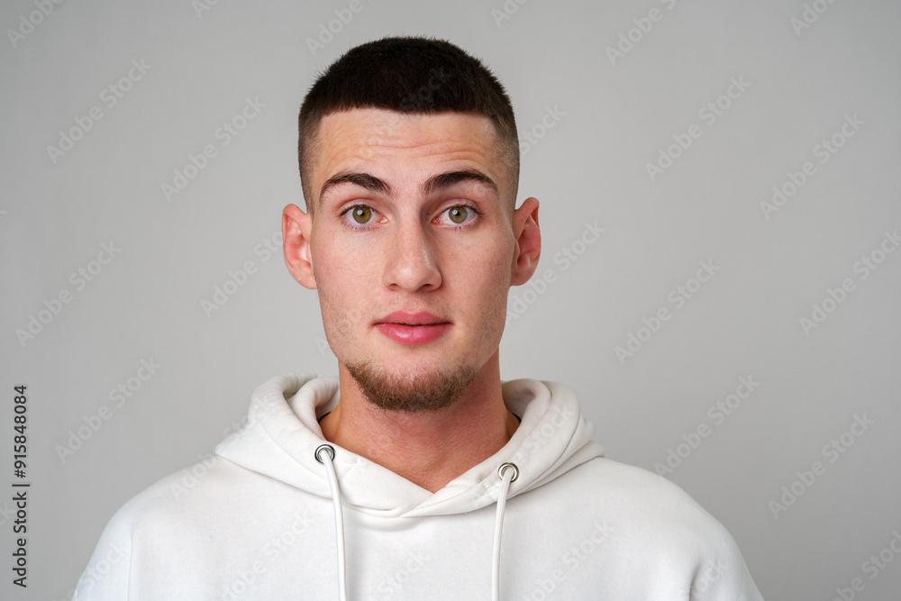 Young Man Looking Surprised Against a Gray Background Young Man Looking Surprised Against a Gray Background