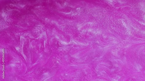 Abstract background with pink shimmery liquid paint.