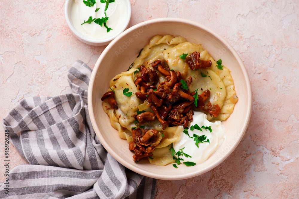 Polish dumplings with fried chanterelles and sour cream on a plate..style hugge. Polish dumplings with fried chanterelles and sour cream on a plate..style hugge.