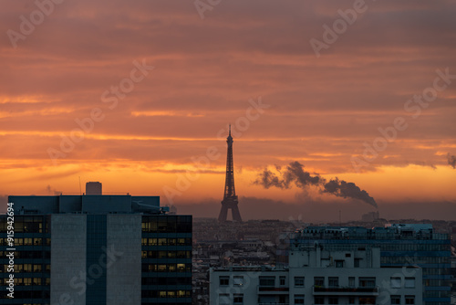 Paris city Skyline with Eiffel with city heating smoke in golden orange sky before sunrise