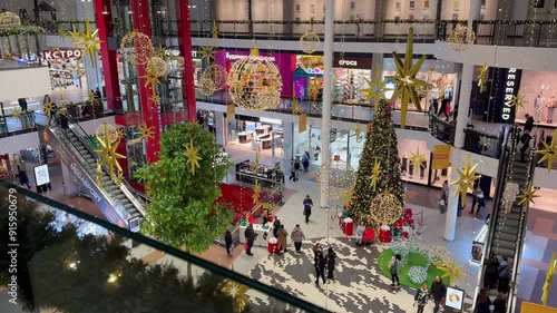 Festive shoppers in modern mall atrium with christmas decorations