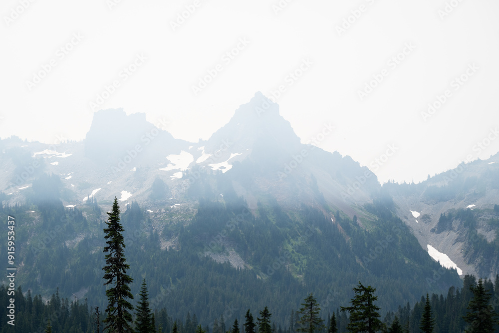 Obraz premium Smoke pollution over the Tatoosh Mountain Range from wildfires, viewed from paradise area of Mount Rainier National Park, poor summer air quality