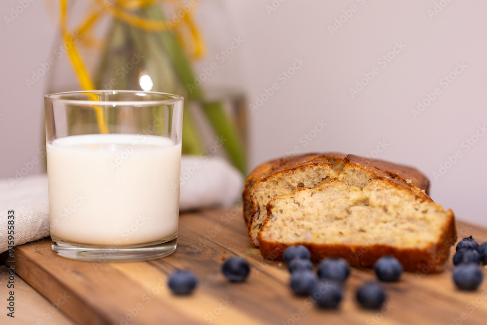 glass of milk and sweet homemade banana bread with crispy crust on a wooden board, dessert glass of milk and sweet homemade banana bread with crispy crust on a wooden board, dessert