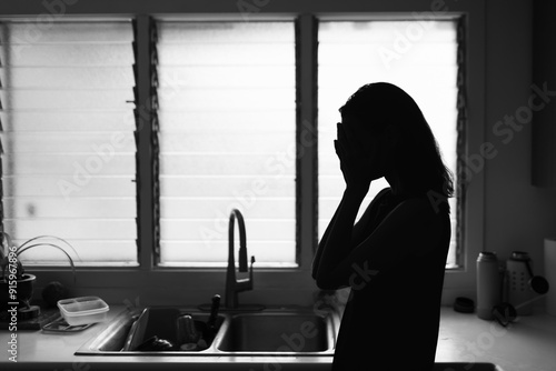 Depressed sad housewife crying at home in the kitchen 