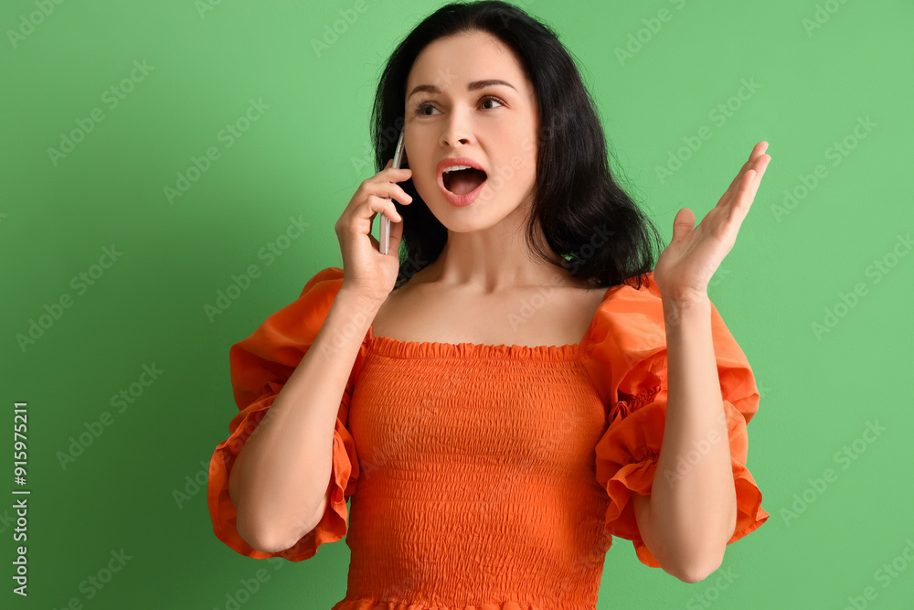 Beautiful woman talking by mobile phone on green background Beautiful woman talking by mobile phone on green background