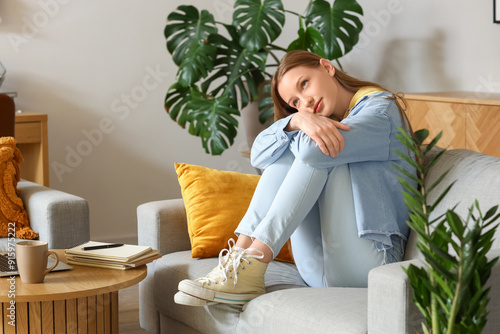 Thoughtful teenage girl sit...