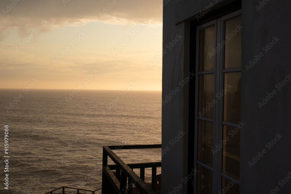Golden hour views from a window overlooking the ocean Golden hour views from a window overlooking the ocean