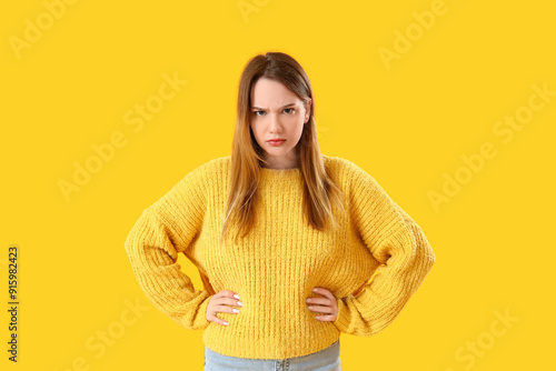 Angry young woman on yellow...