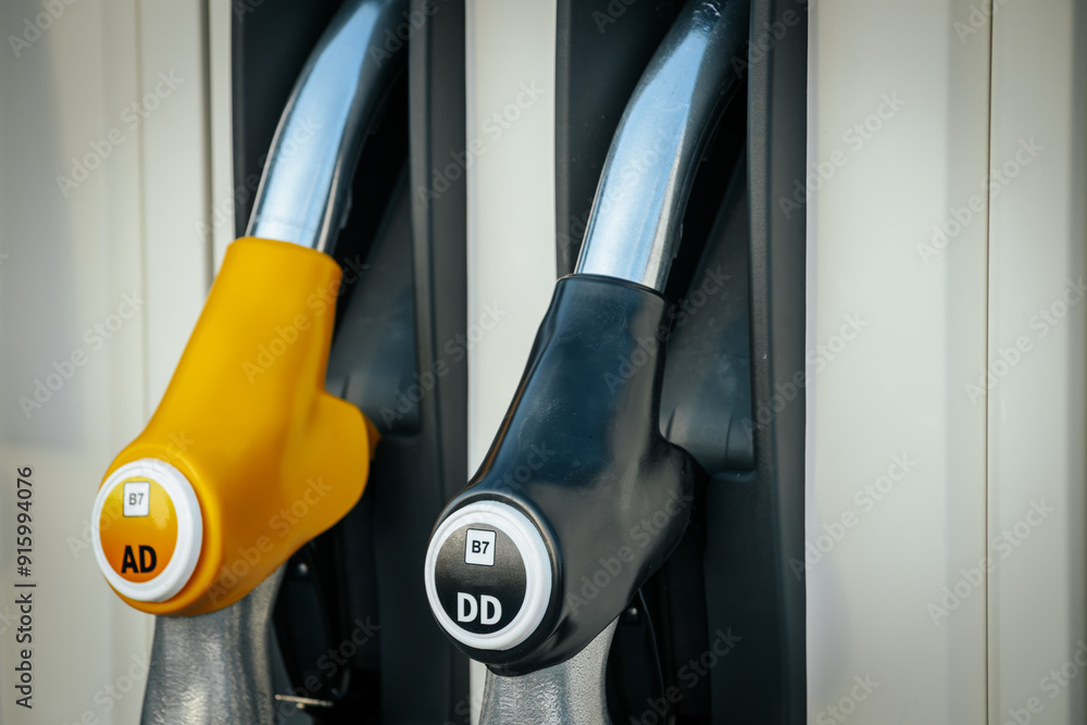 A close up image of fuel nozzles at a gas station, featuring options for 95E, 98E, and DD Diesel. The nozzles are neatly placed in their holders, showcasing the stations fuel variety. A close up image of fuel nozzles at a gas station, featuring options for 95E, 98E, and DD Diesel. The nozzles are neatly placed in their holders, showcasing the stations fuel variety.