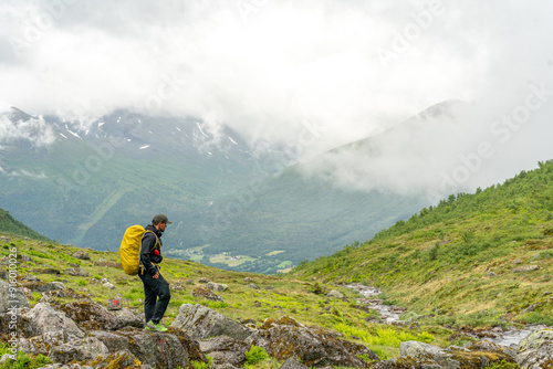 male hiker in the fjord of Andalsnes - Isfjorden in Norway hiking on a rainy cloudy day in the mountains of Massvassbu photo