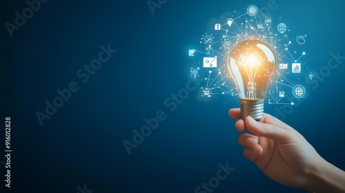 Hand holding light bulb with digital icons and network connection on blue background, representing innovation in technology for business or education. High quality, professional photography