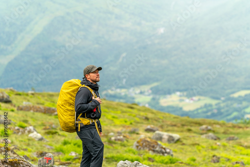 male hiker in the fjord of Andalsnes - Isfjorden in Norway hiking on a rainy cloudy day in the mountains of Massvassbu