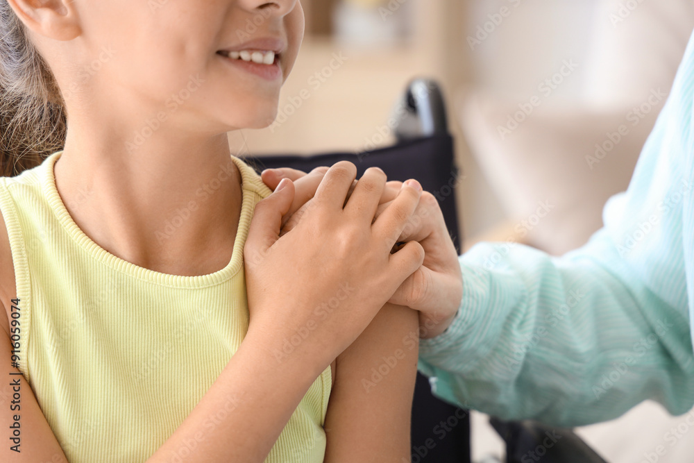 Little girl in wheelchair with her father at home, closeup Little girl in wheelchair with her father at home, closeup