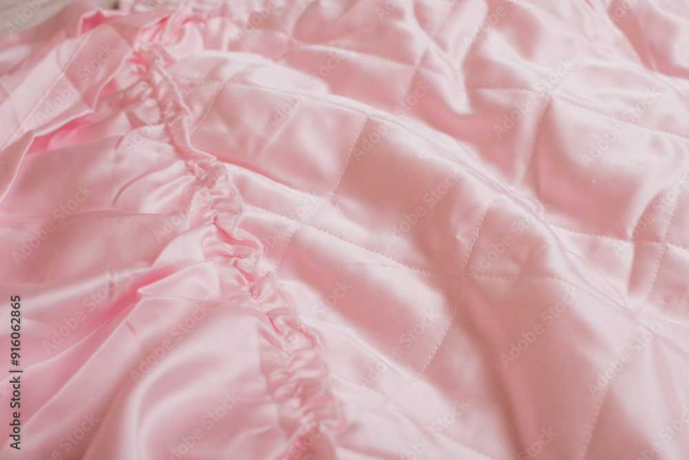 A close-up of a pink quilted blanket with soft folds, perfect for bedding and home decor projects. A close-up of a pink quilted blanket with soft folds, perfect for bedding and home decor projects.