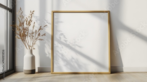 White frame with a blank poster mockup leaning against a plain white wall on a light wooden floor