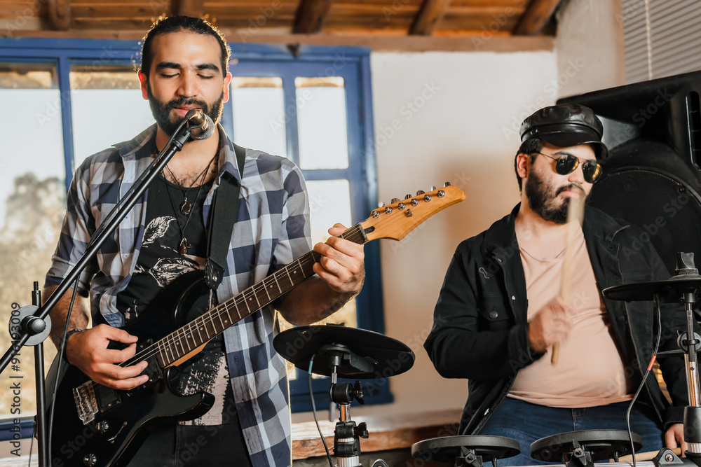 Friends rehearsing at home, guitar and drums. Music band. International music day. Friends rehearsing at home, guitar and drums. Music band. International music day.
