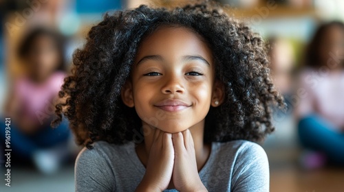 Portrait of a young African American girl with curly hair smiling.