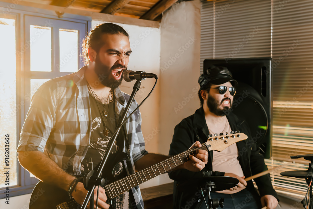 Fototapeta premium Friends rehearsing at home, guitar and drums. Music band. International music day.