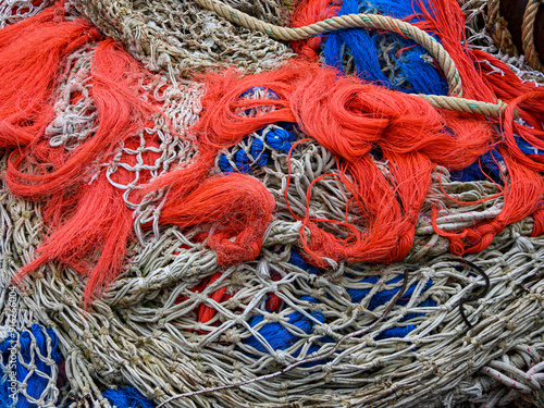 Fishing nets and ropes entangled in a pile on the ground