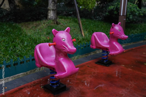 Obraz na płótnie Rainy Day at Children's Playground with Pink Spring Rider w salonie