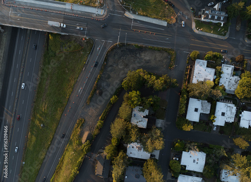 A street view of a residential area with a freeway in the background