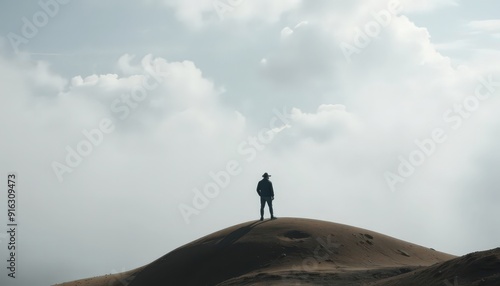 Man Standing on a Hilltop with Foggy Clouds.