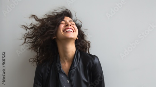 photograph of a businesswoman giving a thumbs up gesture in front of a white wall