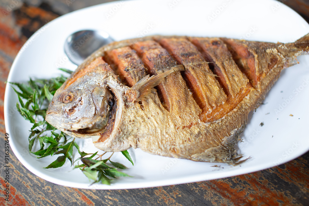 Fried cotton fish with fish sauce placed on a white plate ready to eat. Fried cotton fish with fish sauce placed on a white plate ready to eat.