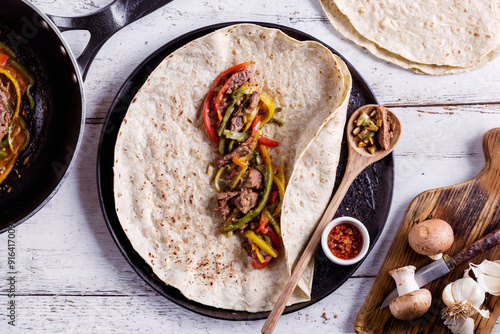 Delicious shaverma, kebab wrap with beef meat steak stripes, sweet pepper and onions. Isolated on white background top view photo