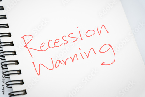 Hand writing Recession Warning on notebook. Global economic crisis. Recession business and stock crisis concept.